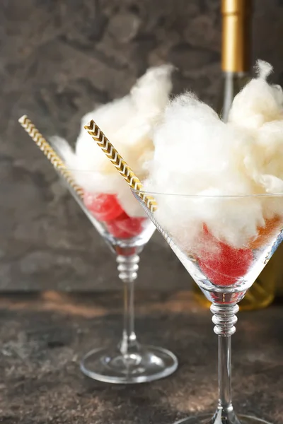 Sabroso algodón de azúcar con dulces en gafas sobre fondo gris —  Fotos de Stock