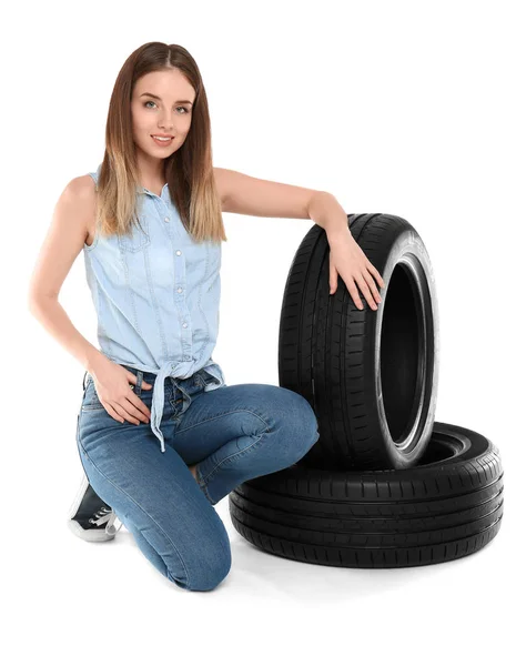 Young woman with car tires on white background — Stock Photo, Image