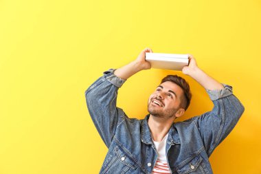 Renk arka plan üzerinde kitapla yakışıklı genç