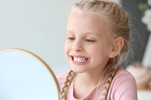 Little girl checking whiteness of her teeth at home — Stock Photo, Image