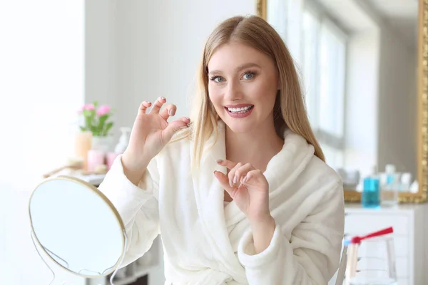 Hermosa mujer que usa hilo dental en casa — Foto de Stock