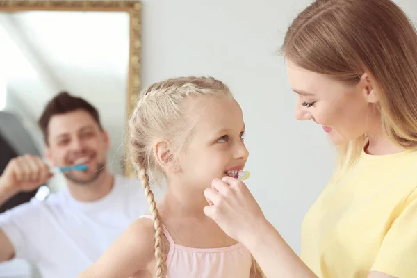Mutter bringt kleinem Mädchen bei, zu Hause Zähne zu putzen — Stockfoto