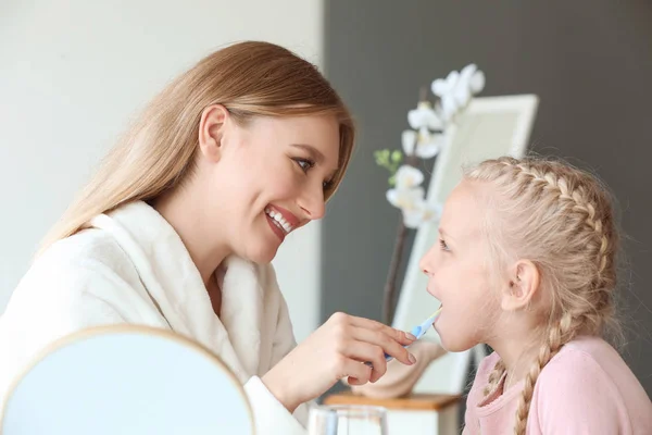 Kobieta czyszczenia zębów jej mała córka w domu — Zdjęcie stockowe