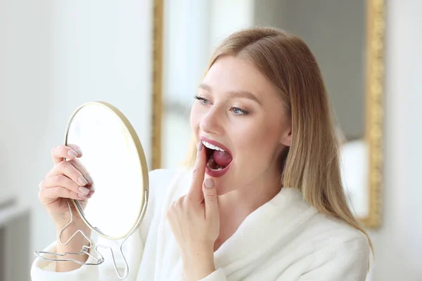 Kvinna kontrollera vithet av tänderna hemma — Stockfoto