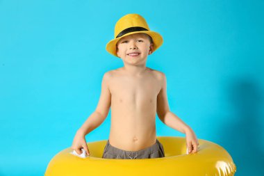 Renkli arka planda şişme yüzük ve şapka ile sevimli küçük çocuk