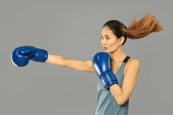 Kvinnlig asiatisk boxare på grå bakgrund — Stockfoto