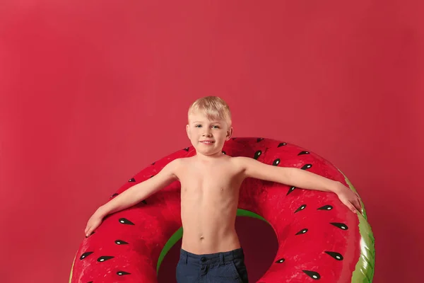Χαριτωμένο μικρό αγόρι με φουσκωτό δαχτυλίδι στο φόντο χρώμα — Φωτογραφία Αρχείου