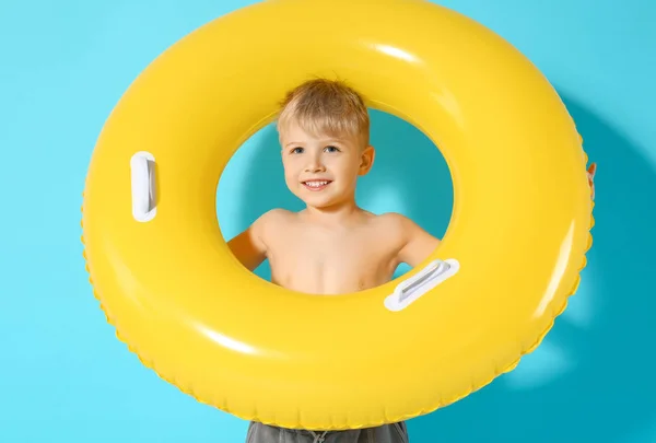 Ragazzino carino con anello gonfiabile su sfondo di colore — Foto Stock