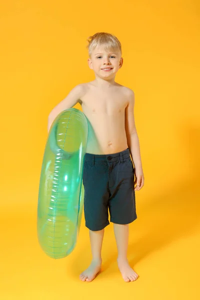 Cute little boy with inflatable ring on color background — Stock Photo, Image