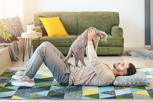 Giovane uomo con simpatico gatto divertente a casa — Foto Stock