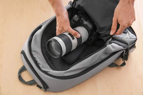 Male photographer putting camera in special bag — Stock Photo, Image