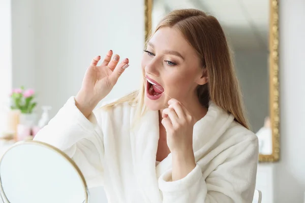 Beautiful woman flossing teeth at home — Stock Photo, Image