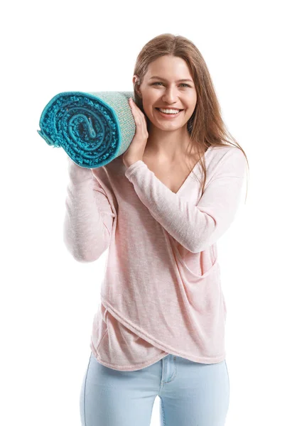 Young woman holding rolled carpet against white background — Stock Photo, Image
