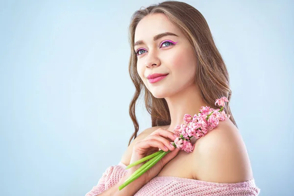 Vacker ung kvinna med hyacint blommor på ljus bakgrund — Stockfoto