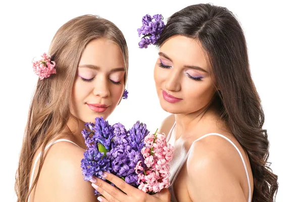 Vackra unga kvinnor med hyacint blommor på vit bakgrund — Stockfoto