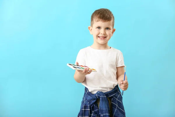 Χαριτωμένο μικρό αγόρι με χρώματα και πινέλο στο φόντο χρώμα — Φωτογραφία Αρχείου