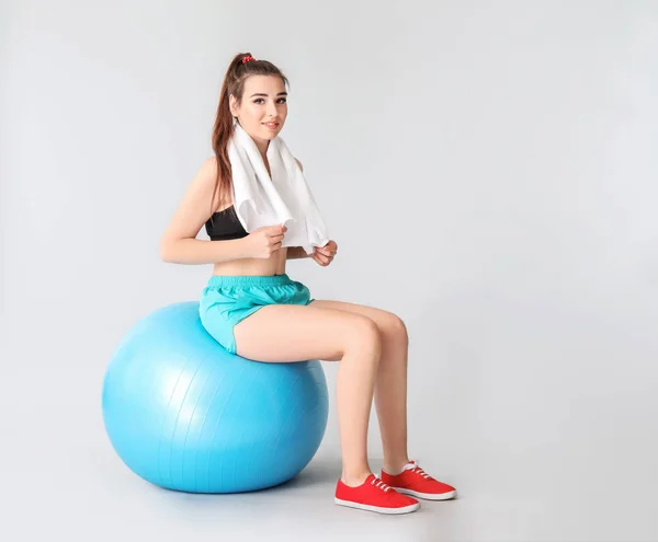 年轻的运动女人与灰色背景的健身球 — 图库照片