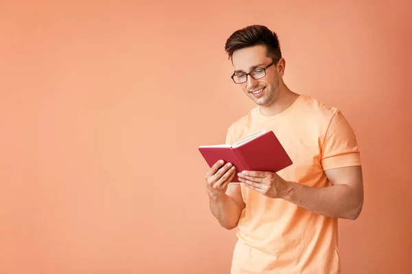 Portrét pohledného muže s knihou na pozadí barev — Stock fotografie