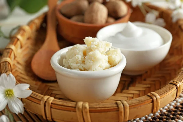 Bowls with shea butter and cream in wicker tray — Stock Photo, Image