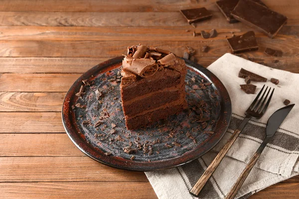 Placa con trozo de sabroso pastel de chocolate en la mesa — Foto de Stock