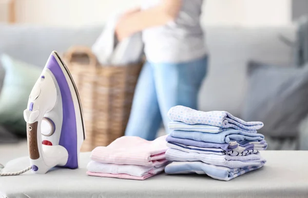 Stacks of clean clothes on ironing board at home — Stock Photo, Image