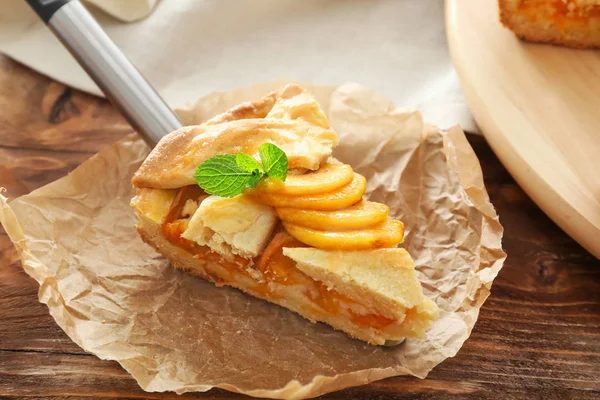 Шматок смачного персикового пирога на дерев'яному фоні — стокове фото