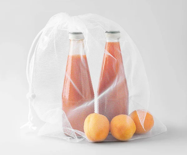 Eco bag con frutta e succo su fondo chiaro — Foto Stock