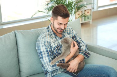 Evde sevimli komik kedi ile genç adam