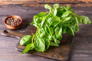 Ahşap masada taze yeşil fesleğen ve baharatlar ile Board