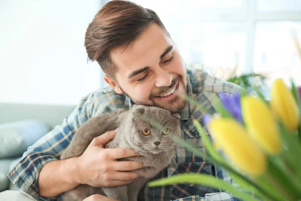 Young man with cute funny cat at home — Stock Photo, Image