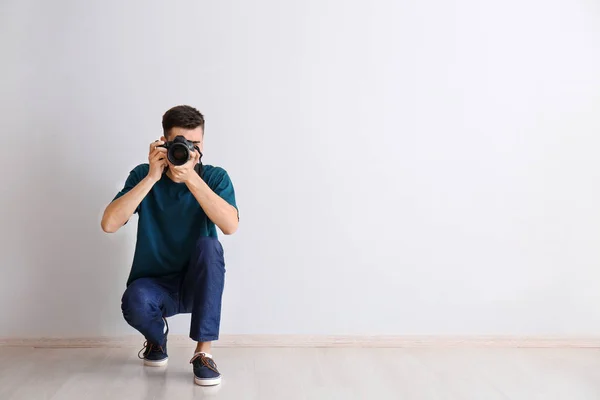 Hombre fotógrafo cerca de pared de luz — Foto de Stock