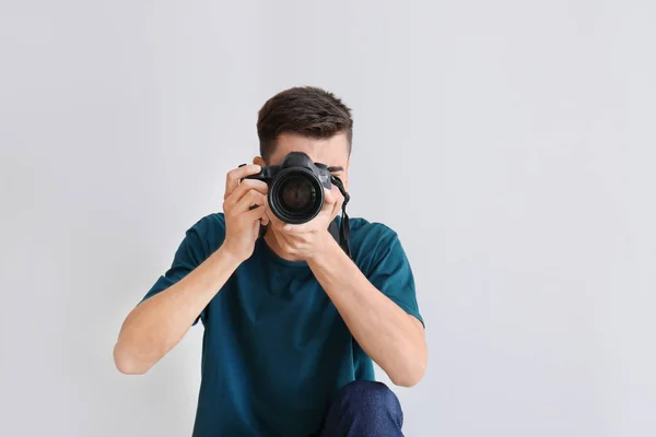 Mannelijke fotograaf op lichte achtergrond — Stockfoto