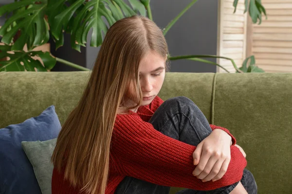 Triste adolescente seduta sul divano a casa — Foto Stock