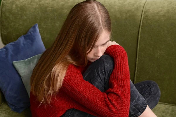Λυπημένο έφηβο κορίτσι κάθεται στον καναπέ στο σπίτι — Φωτογραφία Αρχείου