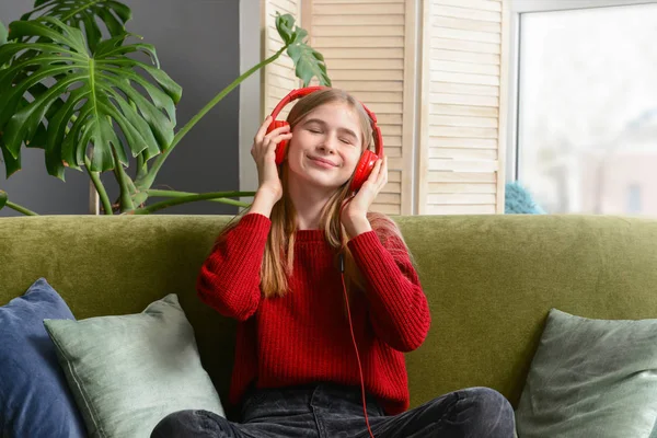 Roztomilá mladá dívka naslouchající hudbě doma — Stock fotografie