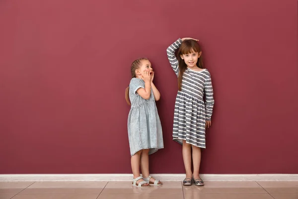 Little girls measuring height near wall — Stock Photo, Image