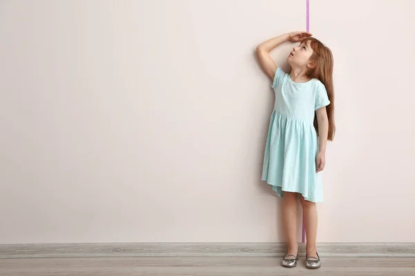 Küçük kız duvar yakın yüksekliği ölçme — Stok fotoğraf