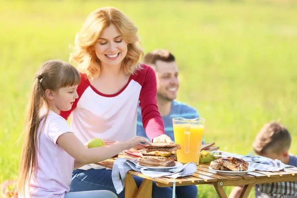 Мати з дочкою сидить за столом на літньому пікніку в парку — стокове фото