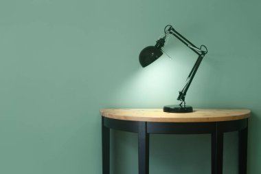 Renkli arka plana karşı masada güzel şık lamba