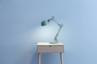 Renkli arka plana karşı masada güzel şık lamba