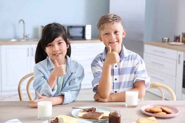 부엌에서 맛있는 토스트를 먹는 재미있는 작은 아이들 — 스톡 사진