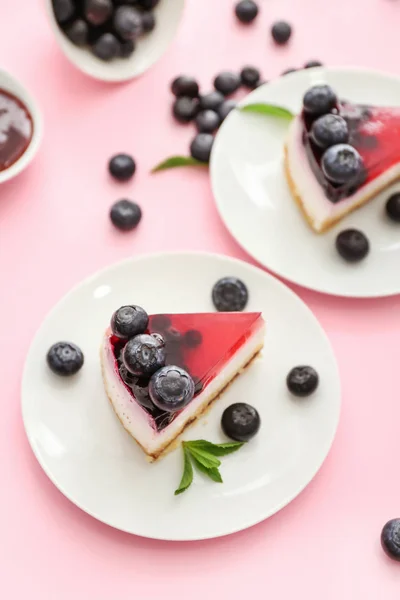 Pieces of tasty blueberry cheesecake on color background — Stock Photo, Image