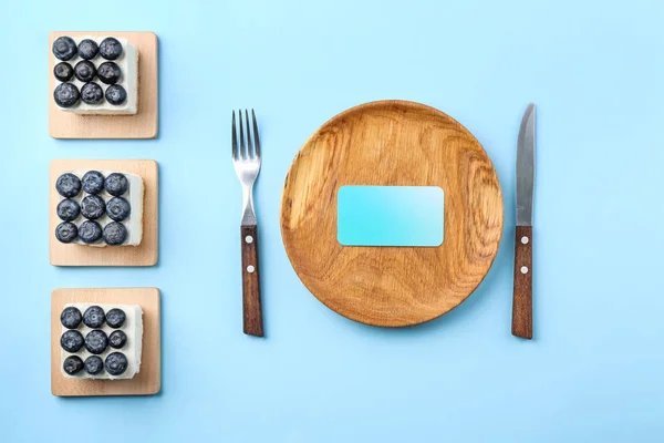 Composición con sabrosos pasteles de arándanos y tarjeta vacía sobre fondo de color —  Fotos de Stock