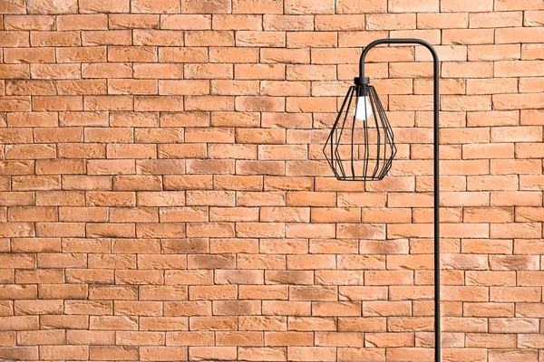 Gyönyörű stílusos lámpa téglafal ellen — Stock Fotó