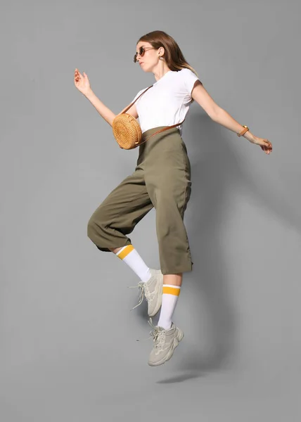 Mujer joven de moda sobre fondo gris — Foto de Stock