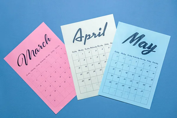 Sheets of paper calendar with spring months on color background — Stock Photo, Image