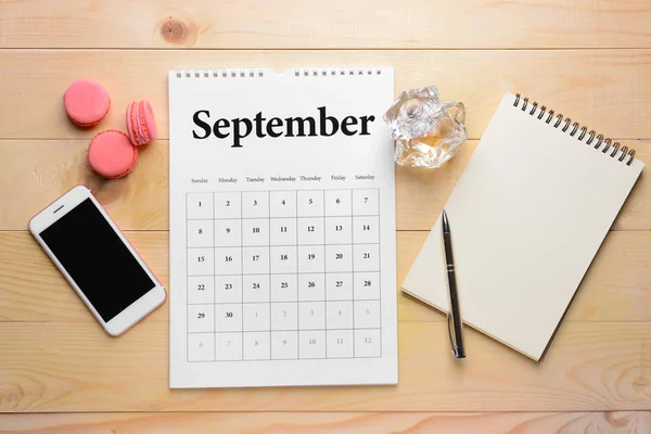 Календарь флип бумаги, мобильный телефон, ноутбук и торты на деревянном фоне — стоковое фото