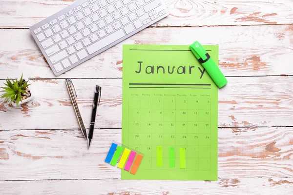 Paper calendar, PC keyboard and stationery on light wooden background — Stock Photo, Image
