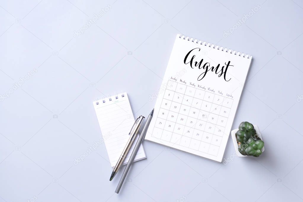 Flip paper calendar and notebook on light background