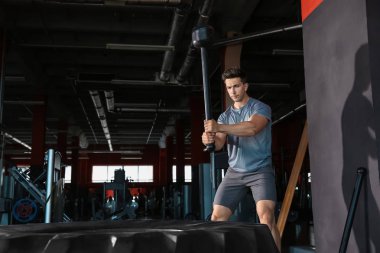 Spor salonunda lastik ile sportif genç adam eğitimi